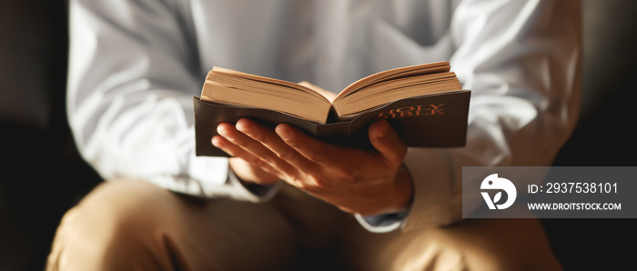 Asian man The faithful and Christian holding cross is reading the Bible to pray to Jesus in the cruc