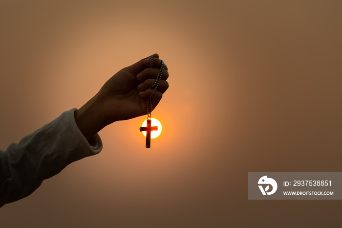 A woman holding a crucifix Sunset backdrop Christian religious concepts, crucifixion of faith and fa