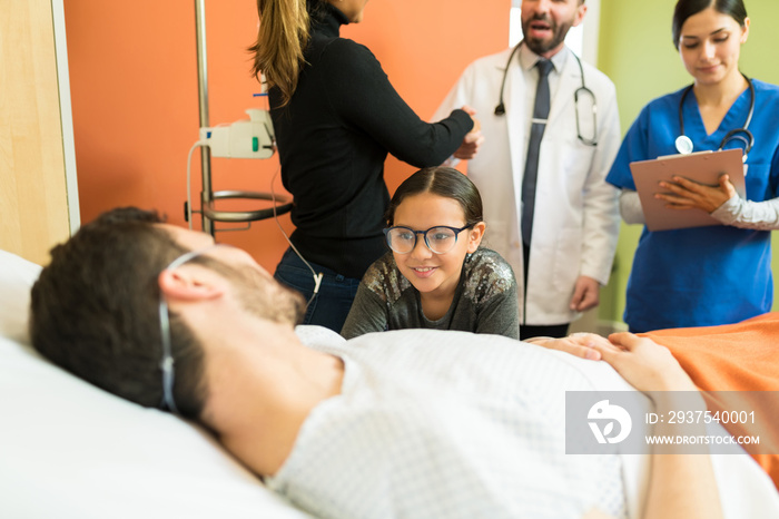 Girl Looking At Father While Woman Greeting Doctors