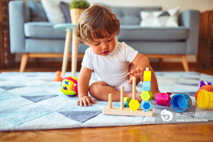 Beautiful toddler child girl playing with toys on the carpet