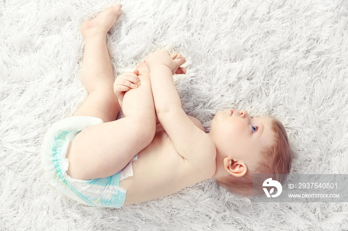 Cute baby boy on carpet, on light background