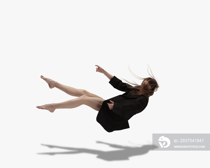 飞翔。年轻漂亮的女孩，女芭蕾舞演员，在白色背景下与阴影隔离跳舞