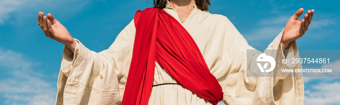 panoramic shot of jesus with outstretched hands against blue sky