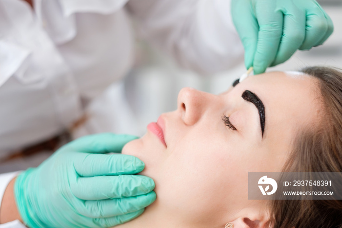 Beautician performing henna brows correction