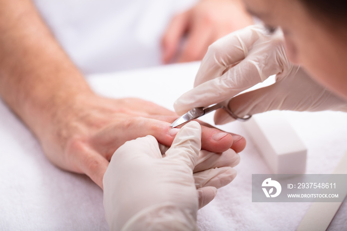 Manicurist Removing Nail Edges With Scissors