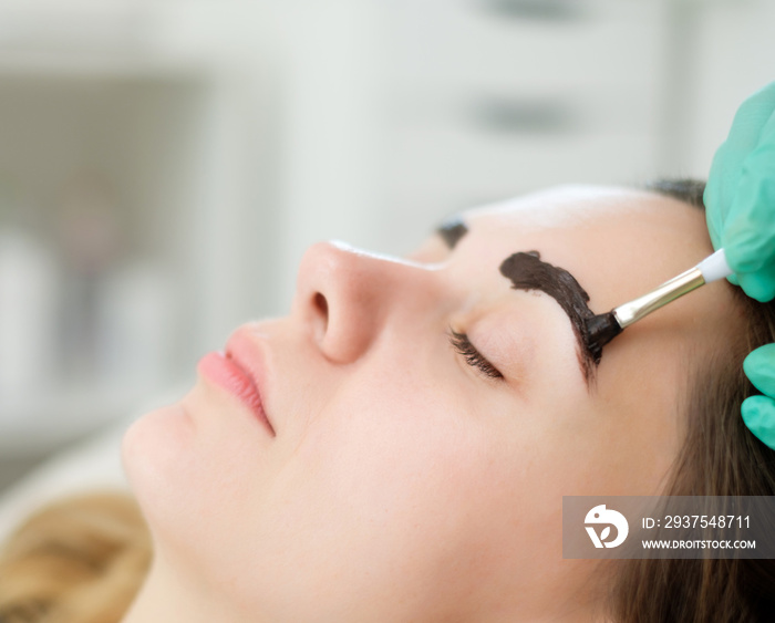 Beautician performing henna brows correction