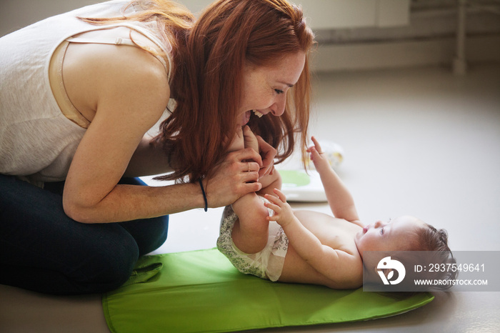 Mother kissing baby girls (6-11 months) feet