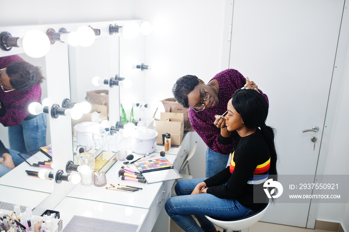 化妆师在美容院化妆的非裔美国妇女。
