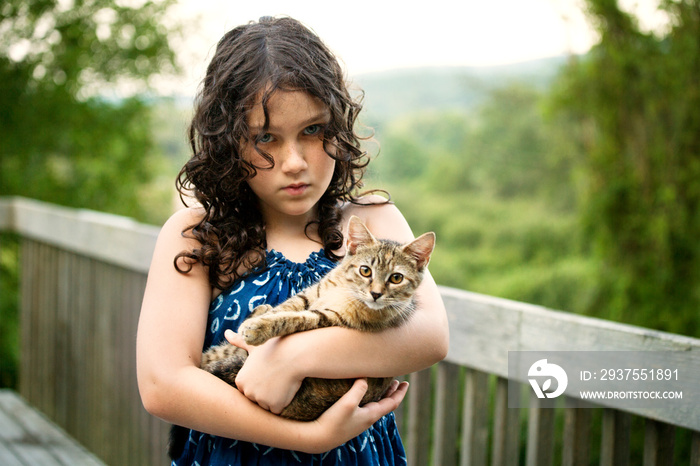 Portrait of girl with cat standing on footbridge