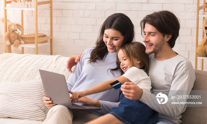 Cute Little Girl Using Laptop With Her Parents At Home