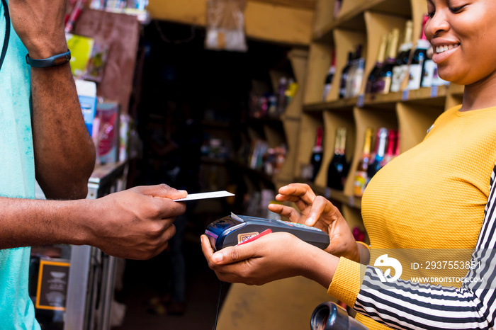 black female merchant in a retail store using a mobile point of sale system to process a customers 