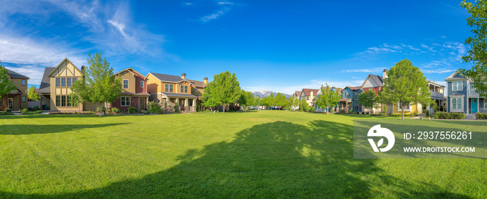 Large green field with trees in the middle of residential are at Daybreak, Utah