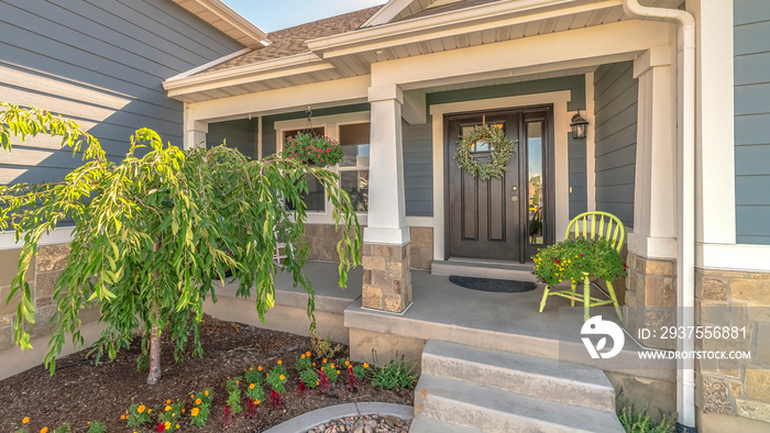 Pano frame Home with landscaped yard stairs porch and front door with sidelight and wreath