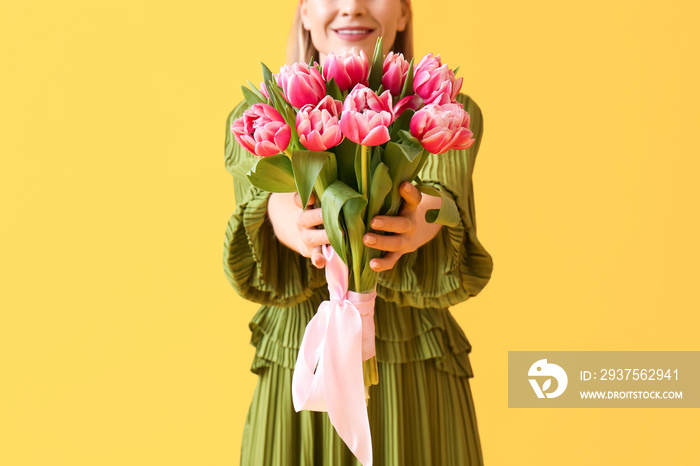 Beautiful woman with bouquet of tulips on yellow background, closeup. International Womens Day