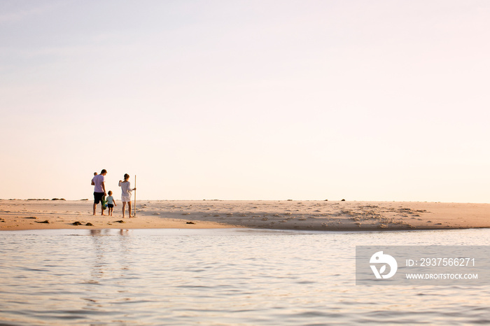 Family with two children (0-1 month, 2-3 years) on beach