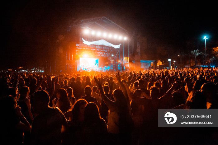 View of a concert with people or audience with hands in the air and clapping at a music festival. Su