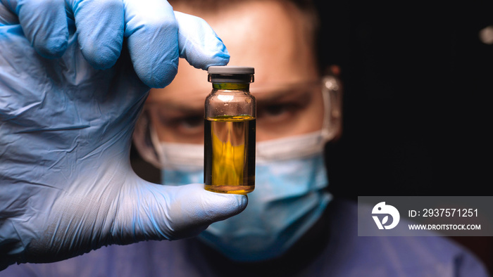 Male doctor in work uniform wearing gloves with goggles goggles examines in vitro analysis. Concept 