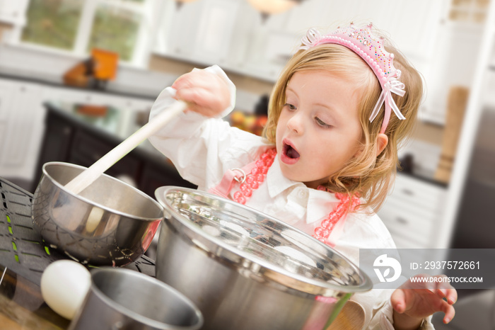 可爱的女婴在厨房里用锅碗瓢盆做饭