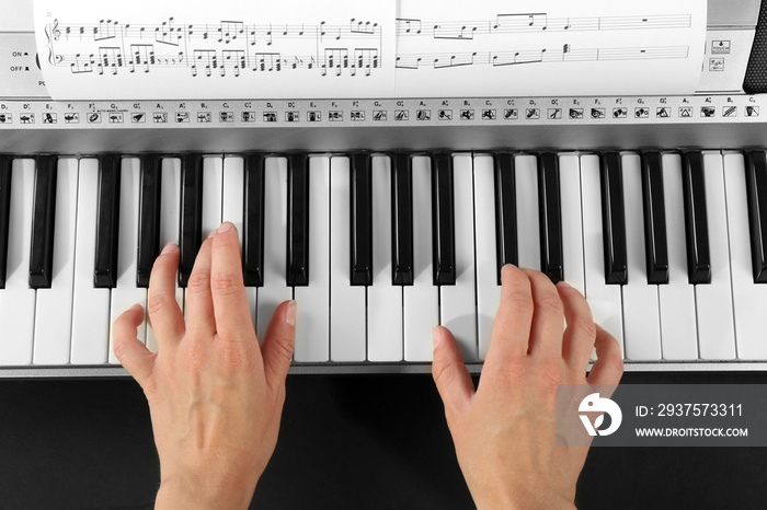 Woman playing synthesizer close up