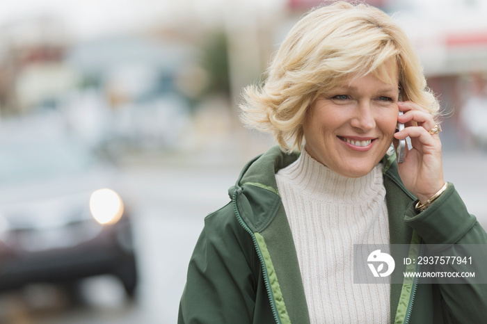 Pretty middle-aged woman on cell phone while walking