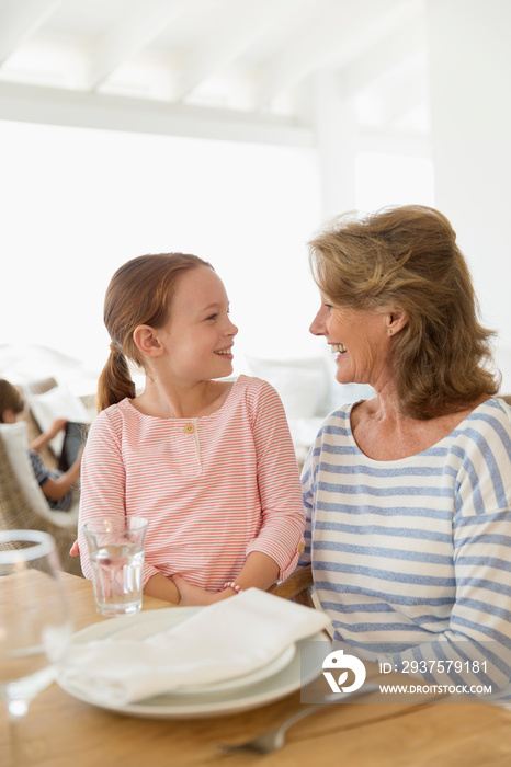 Grandmother and granddaughter talking at able