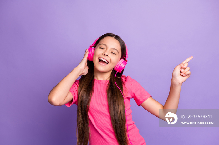 Photo portrait of nice schoolgirl holding pink earphones singing song listening to favourite music i