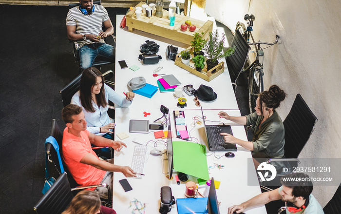 Young co-workers team talking during startup - Happy people planning a new project in creative workp