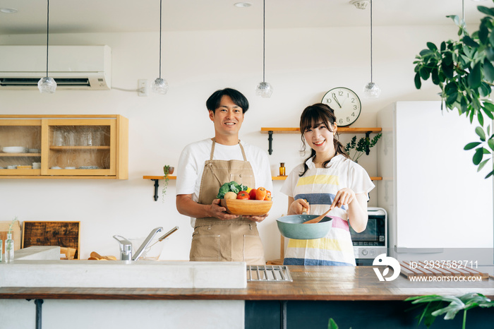 一緒に料理を作る男女（夫婦・フライパンと野菜）