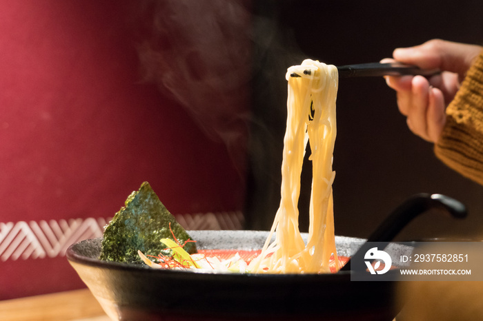 女性手拿筷子上的面条拉面，带复制空间的食品和饮料浓缩物