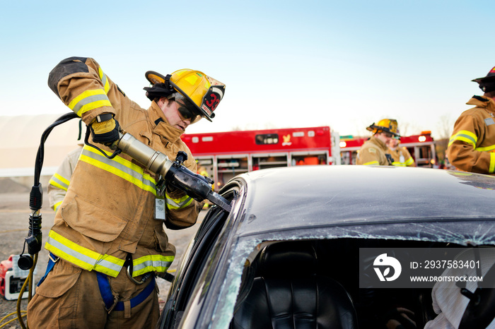 Firefighters tending damaged car at accident site