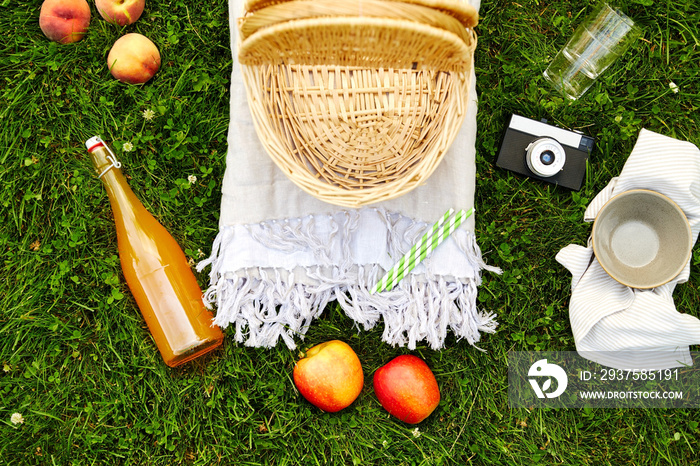 leisure and summer concept - close up of food, drinks and picnic basket on grass