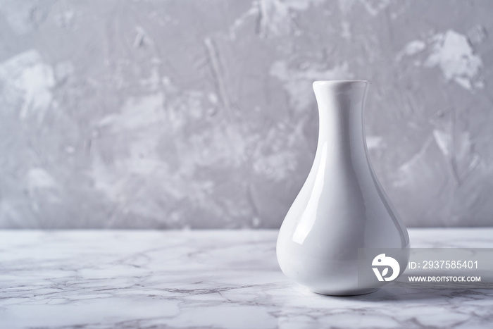 White vase isolated on plaster grey wall background, copy space. Home decor