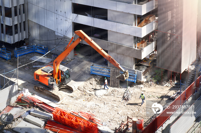 挖掘机或反铲正在地面、开发用地和居民楼上工作和挖掘