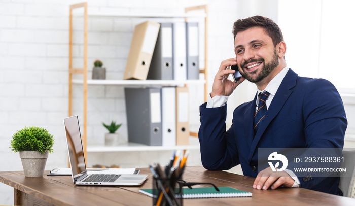 Good business talk. Man talking on phone and smiling