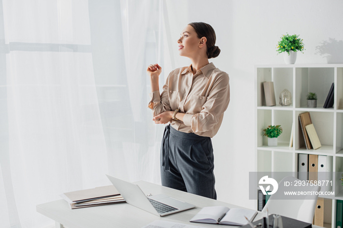 happy tired businesswoman stretching arms in modern office