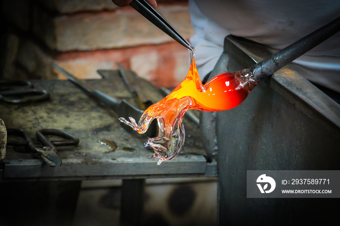 Glass Artist in her workshop making glassware