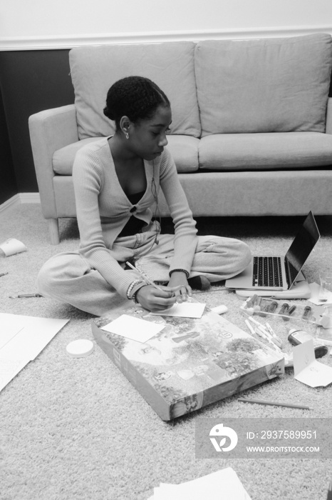 Teenager sitting on the floor with a laptop