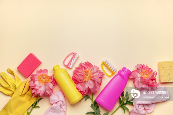 Set of cleaning supplies and spring flowers on color background