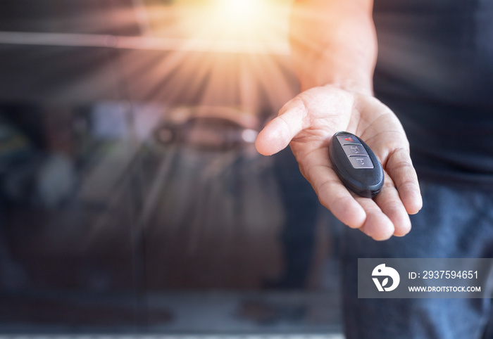 Car key remote on hand. Hand man giving a car remote.