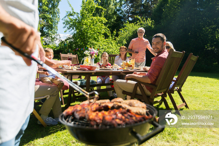 man cooking meat on barbecue grill at summer party