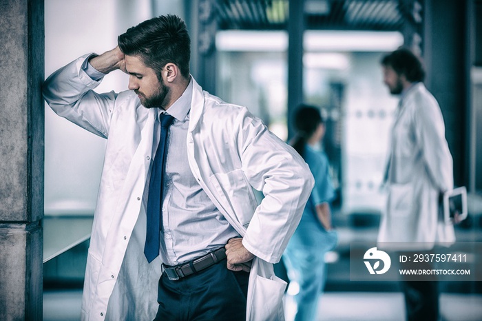 Stressed doctor standing in hospital