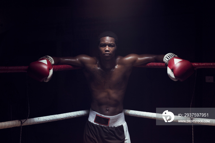 Portrait of boxer leaning while standing in boxing ring