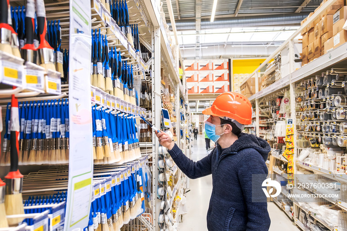 A man in a hardware store. Sells paint brushes. Selective focus.