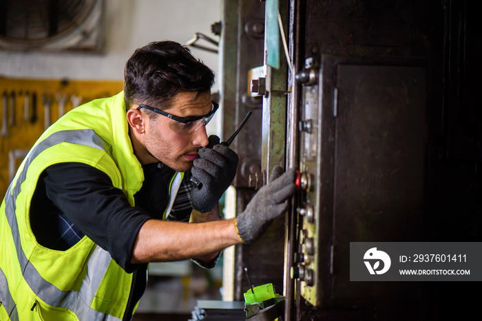 Caucasian engineer mechanic man checking for maintenance pressing metal machine by laptop at factory