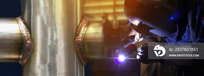 Welder is welding the steel in the factory.