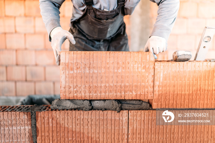 工业工人建造内墙，用水泥砌砖。工人带工具和