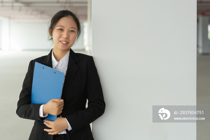 Woman office worker agent holding blue file folder in hands. Young elegant businesswoman or secretar