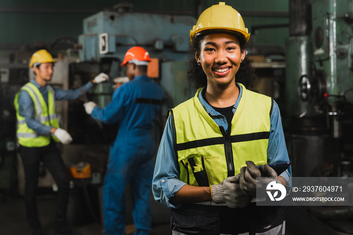 portrait of African engineering women holding tablet to check engine in factory