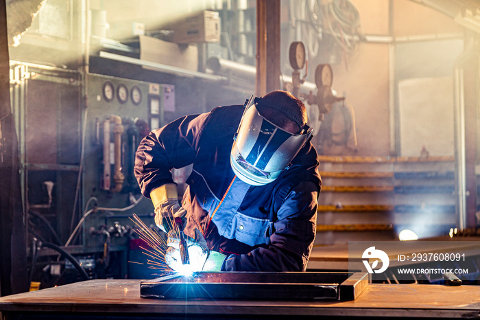 A welder welding in factory