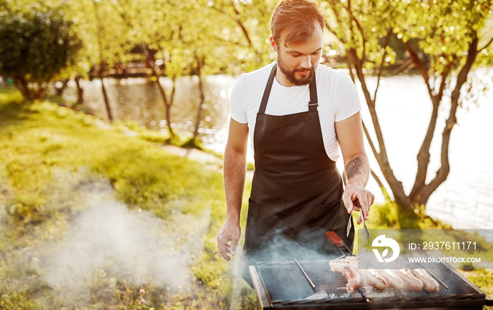 Chef smoking sausages on grill